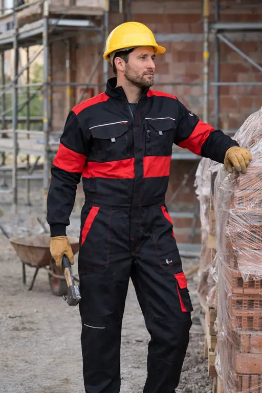 Operatore edile in cantiere con tuta da lavoro uomo nera e rossa multitasche ad alta resistenza