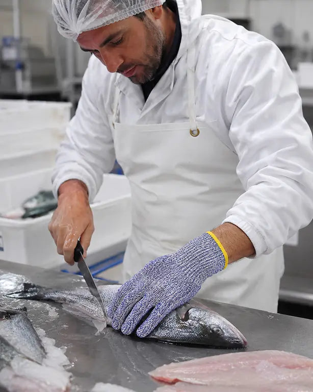 Operatore alimentare che utilizza guanto antitaglio HDPE livello D durante la lavorazione del pesce – PWSTORE